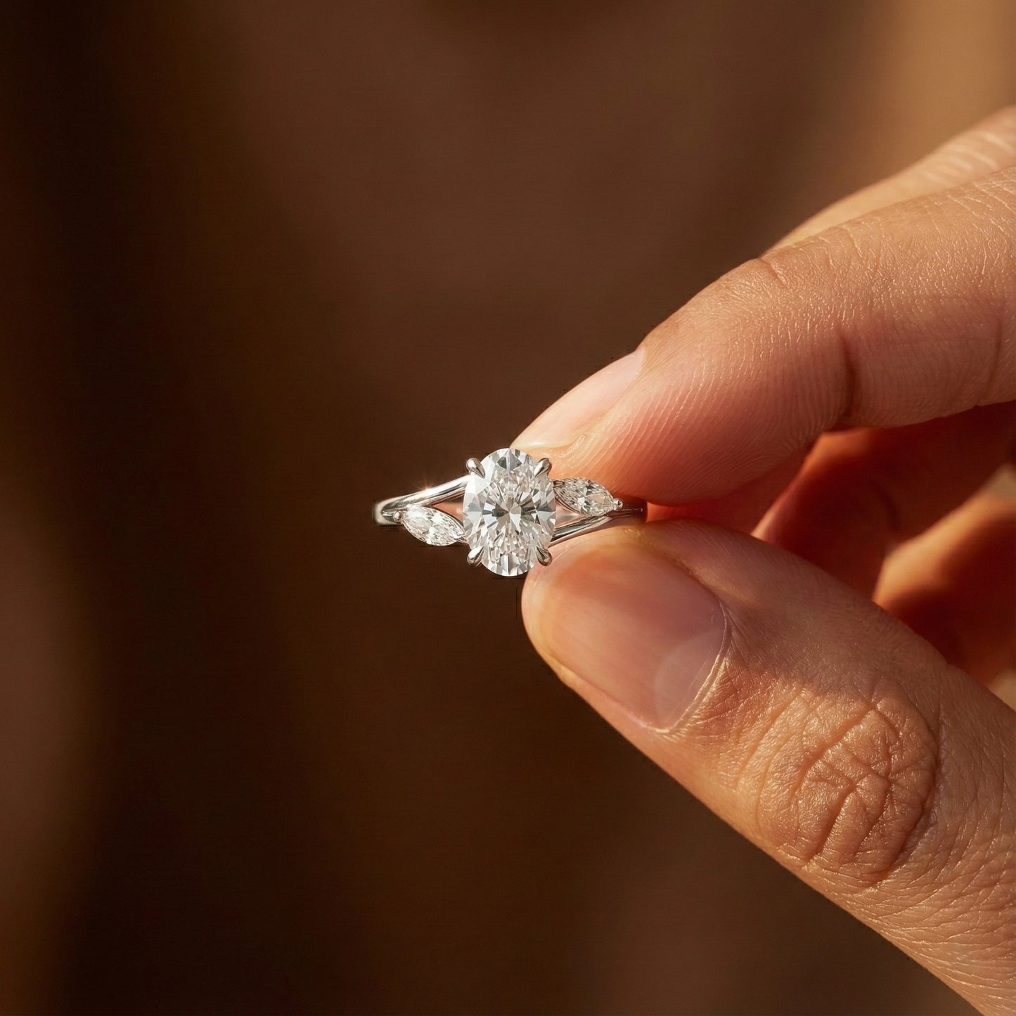 Diamond ring held between fingers against a blurred background