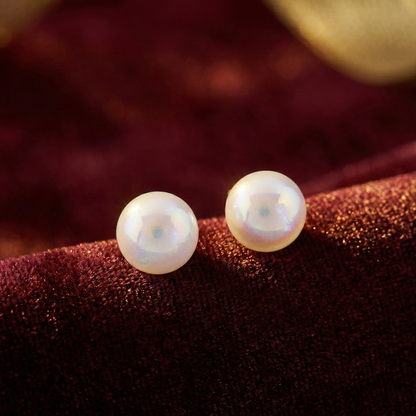 Minimalist pearl stud earrings photographed in soft lighting