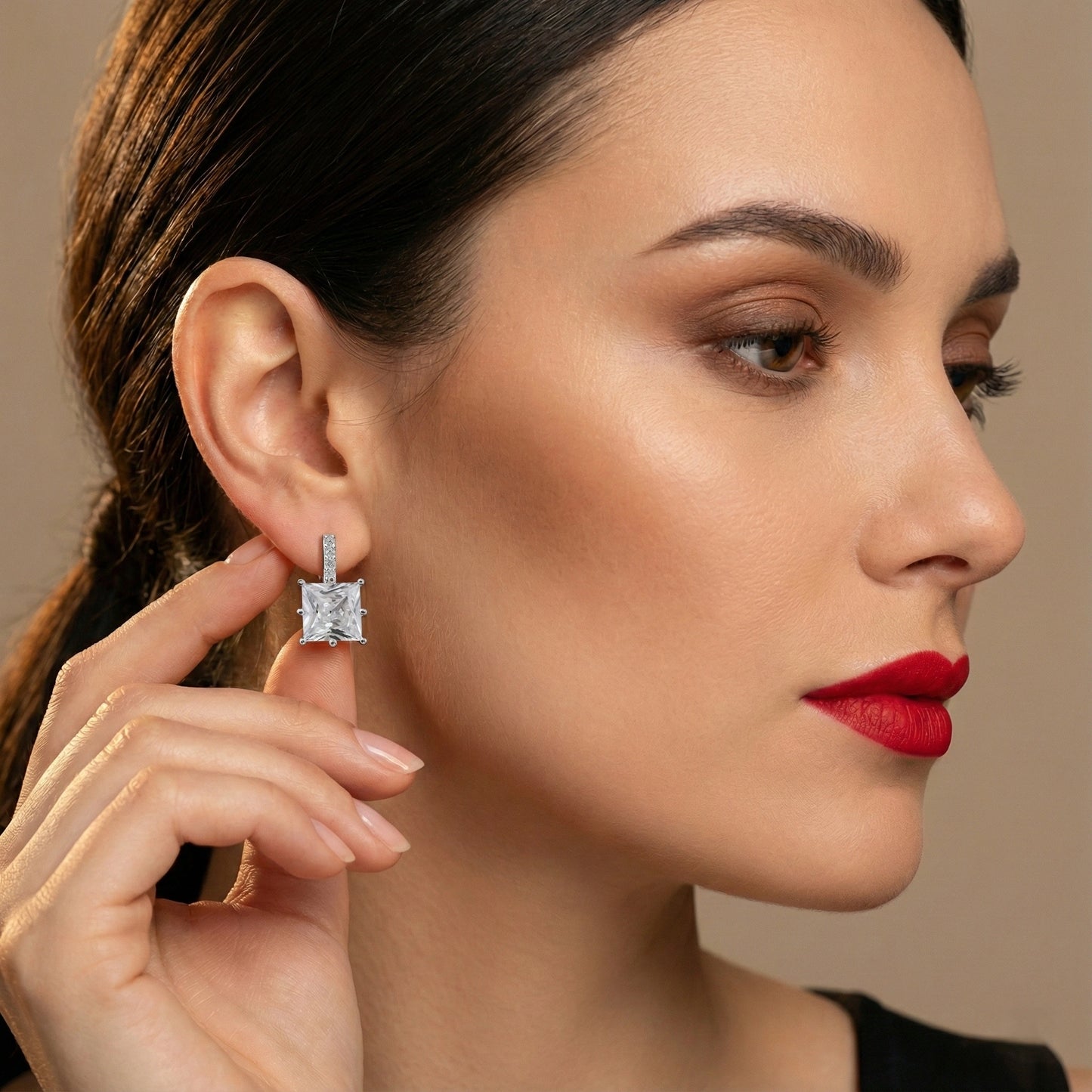 Woman wearing a diamond earring with a neutral background