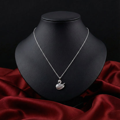 Silver necklace with a swan pendant on a black mannequin bust against a dark background.