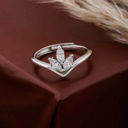 Silver ring with marquise-shaped diamonds on a brown fabric background