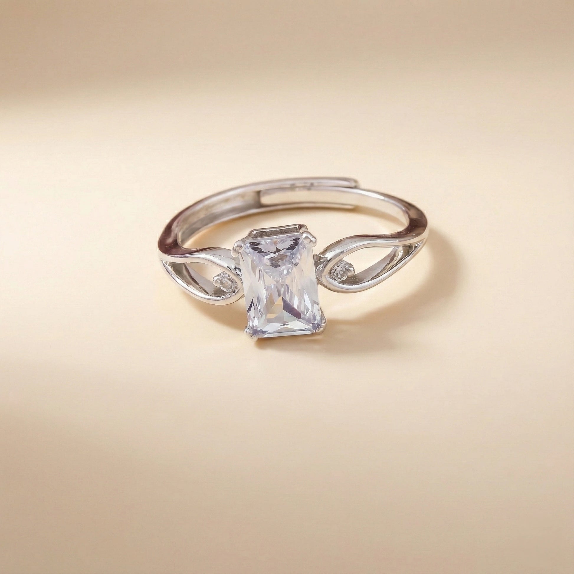 Silver ring with a large rectangular gemstone on a beige background