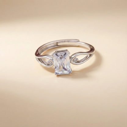 Silver ring with a large rectangular gemstone on a beige background