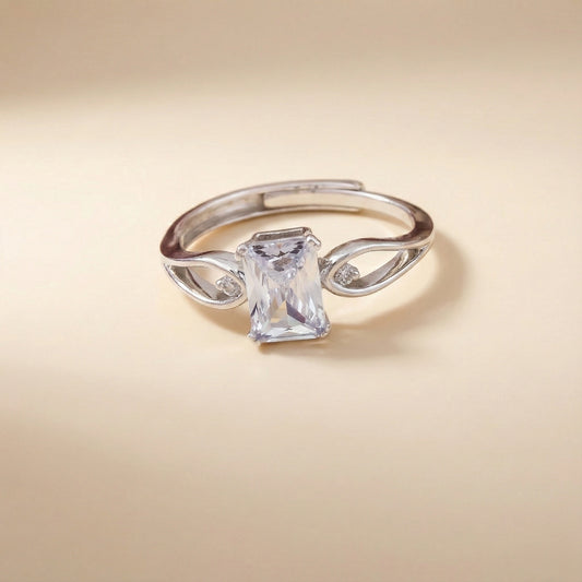 Silver ring with a large rectangular gemstone on a beige background