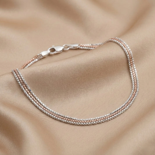 Two-layered silver bracelet on a beige fabric background