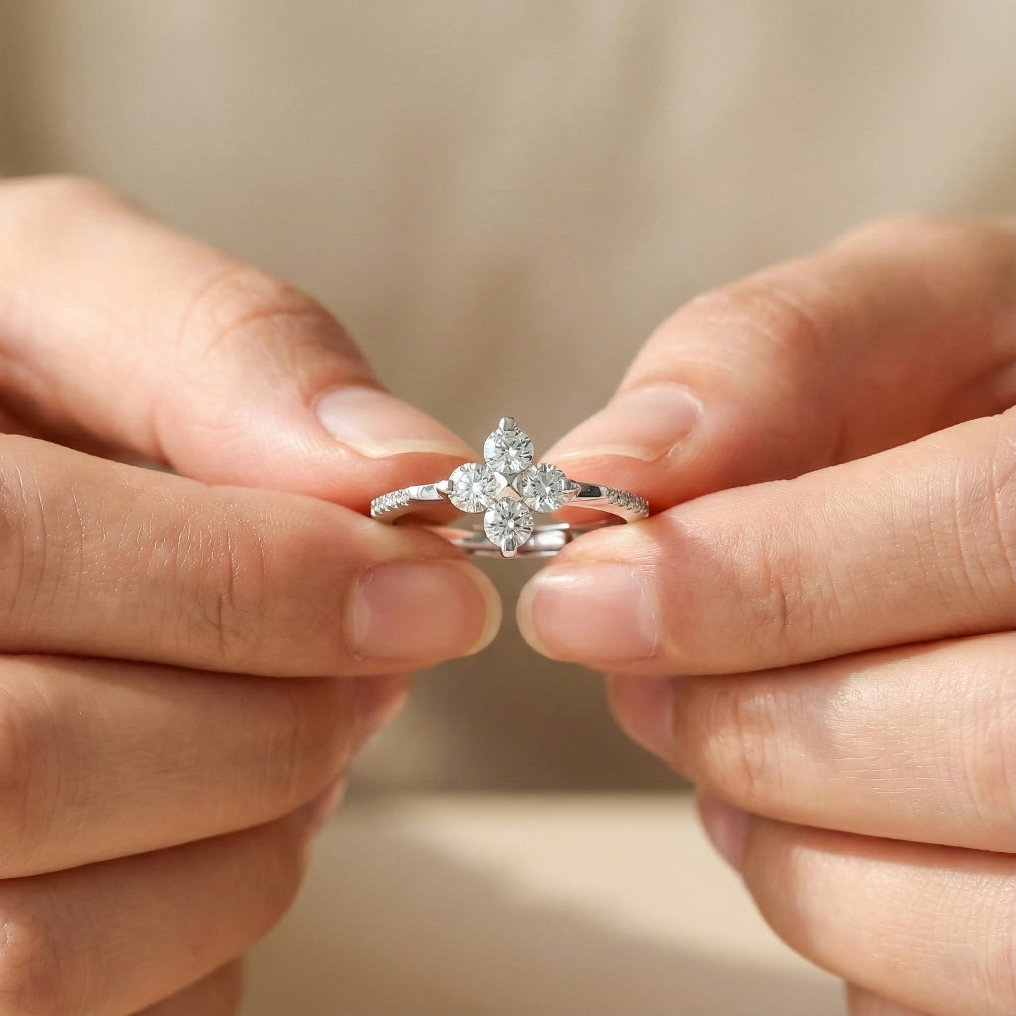 Close-up of hands holding a diamond ring against a blurred background