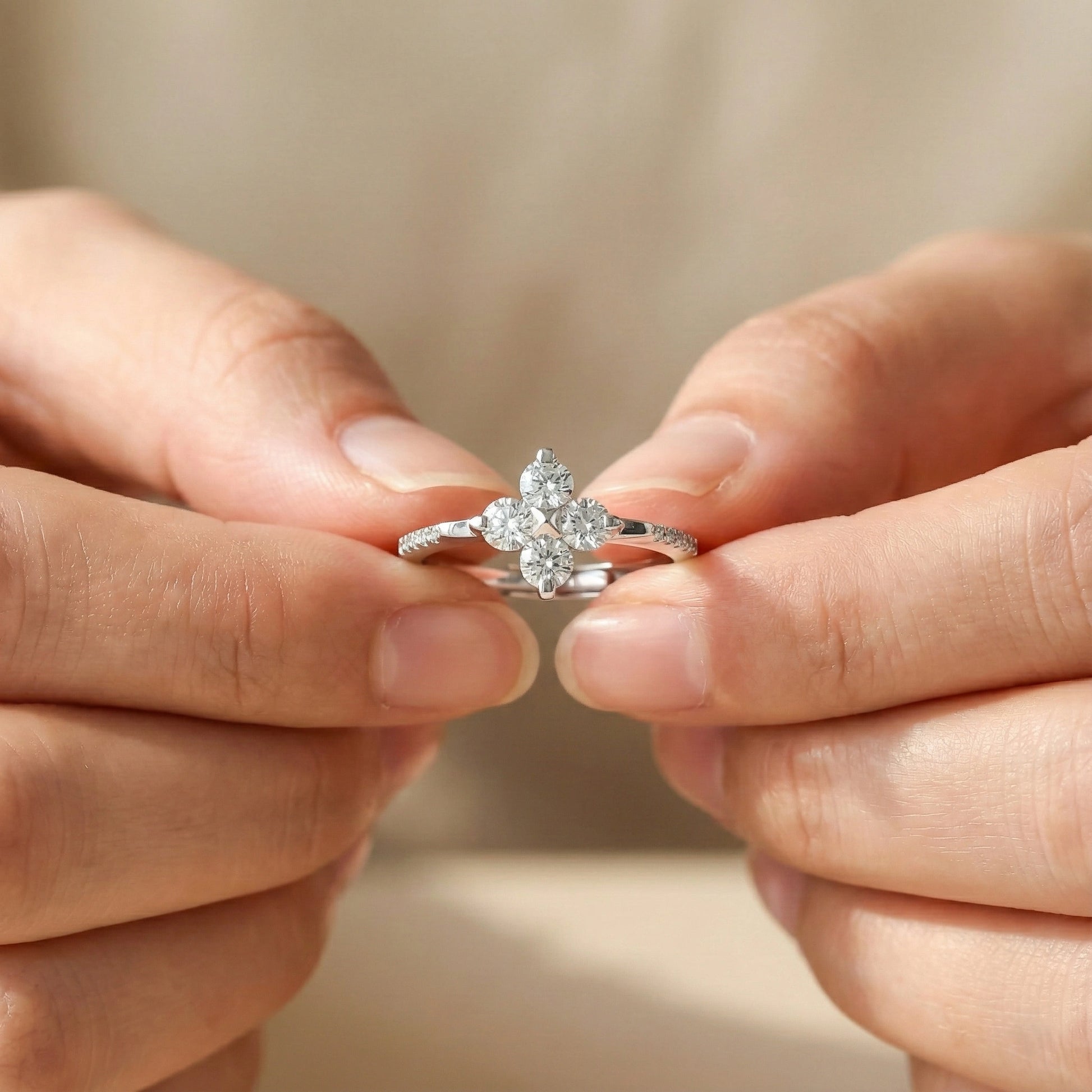 Close-up of hands holding a diamond ring against a blurred background