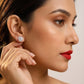 Close-up of a woman wearing a diamond earring with a neutral background