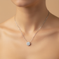 Silver necklace with a floral pendant on a mannequin against a beige background