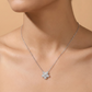 Silver necklace with a floral pendant on a model against a beige background
