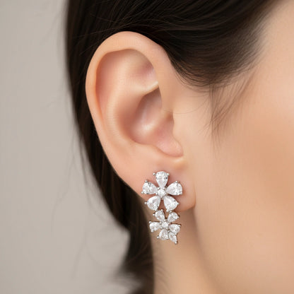 Close-up of an ear wearing a pair of diamond earrings with a neutral background