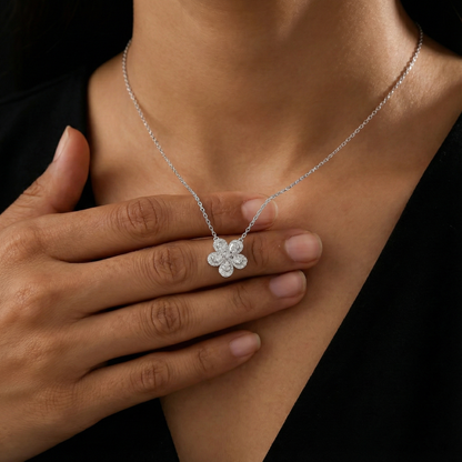 Silver necklace with a flower-shaped pendant worn by a person