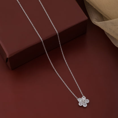 Silver necklace with a flower pendant on a brown surface