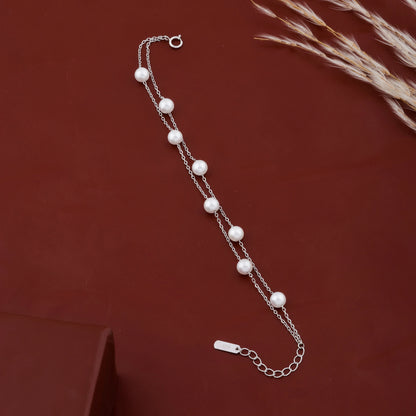 Minimalist silver pearl bracelet flat lay close up