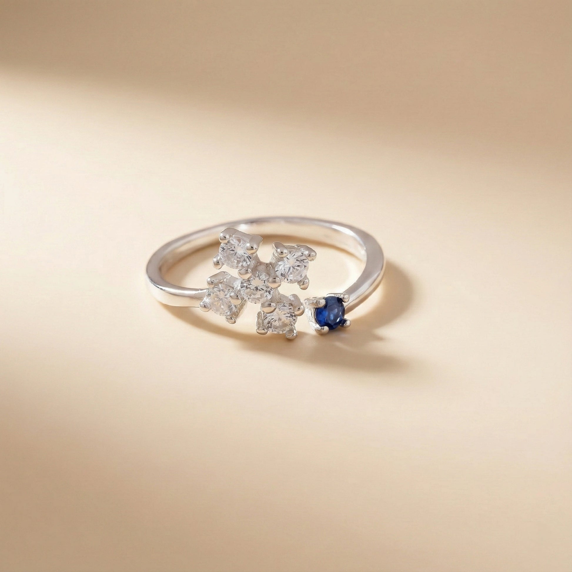 Silver ring with diamond and sapphire on a beige background