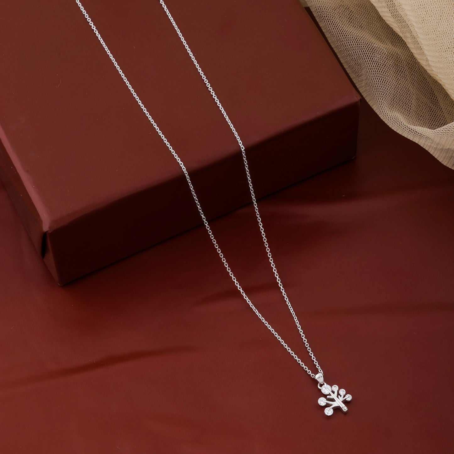 Silver necklace with a paw print pendant on a brown surface