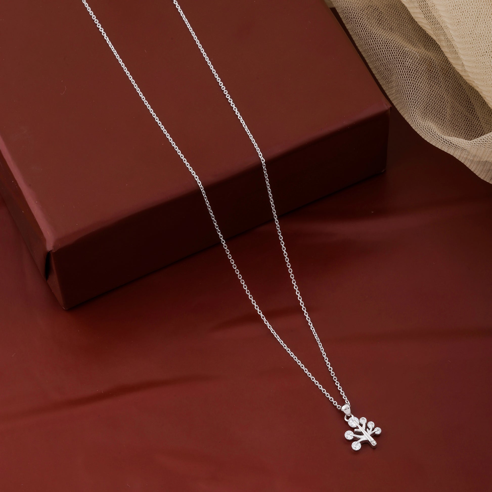 Silver necklace with a paw print pendant on a brown surface