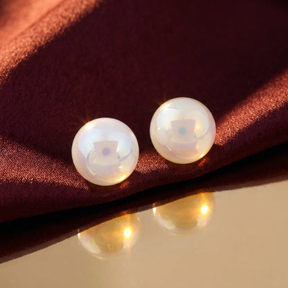 Classic round pearl earrings with polished shine placed side by side