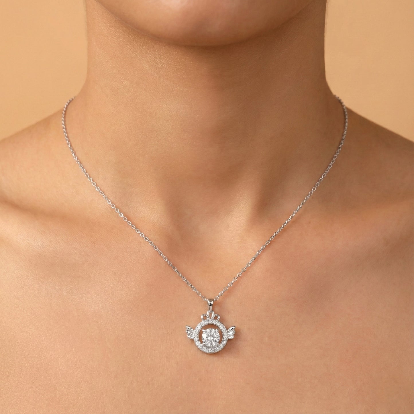 Silver necklace with a pendant on a person against a beige background