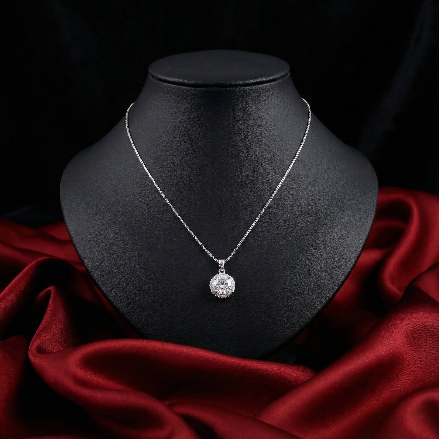 Silver necklace with a round pendant on a black mannequin bust against a dark background