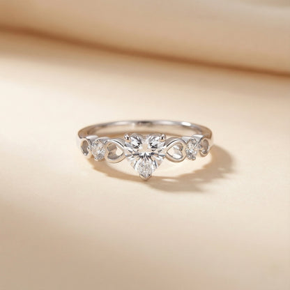 Silver ring with floral design and clear gemstones on a beige background