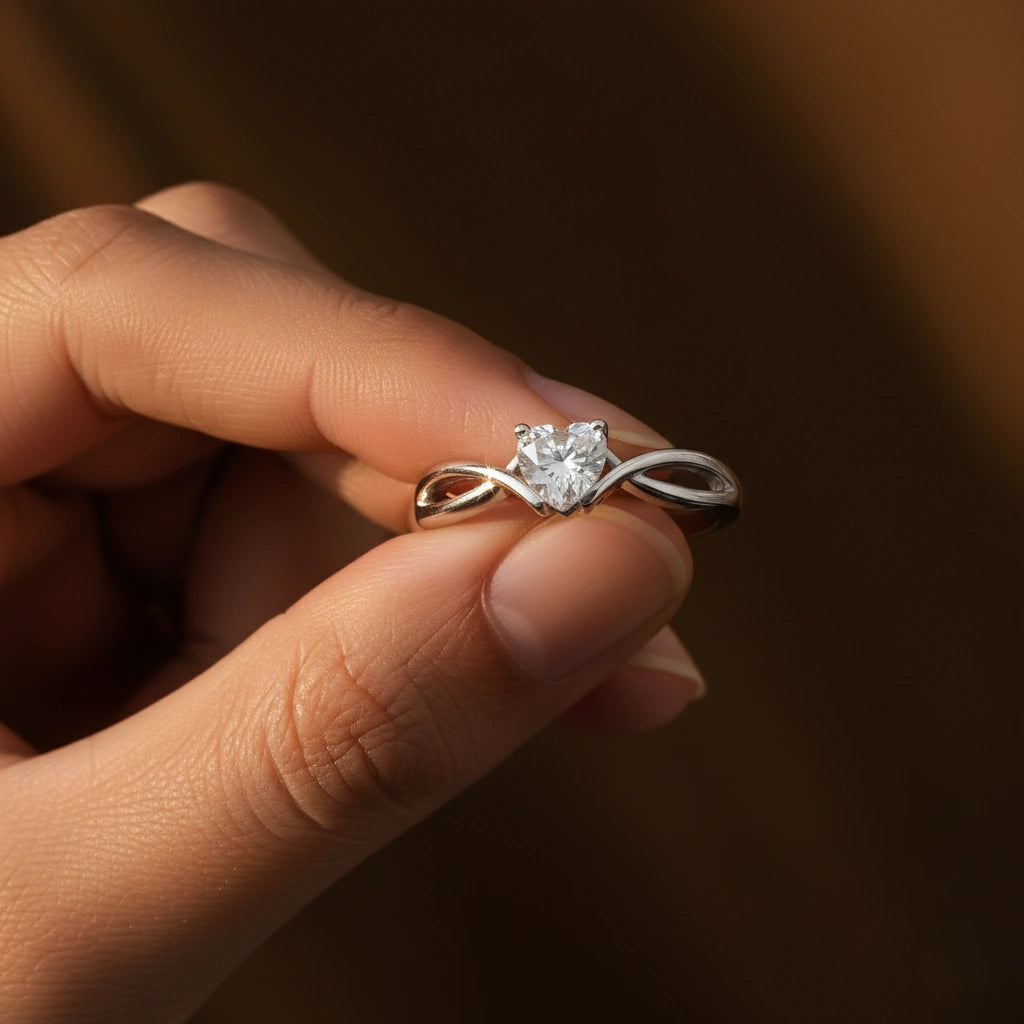 Heart-shaped diamond ring held between fingers against a dark background