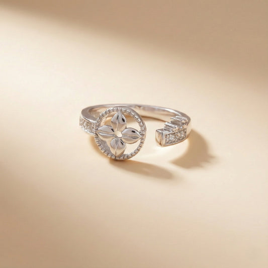 Silver ring with floral design on a beige background