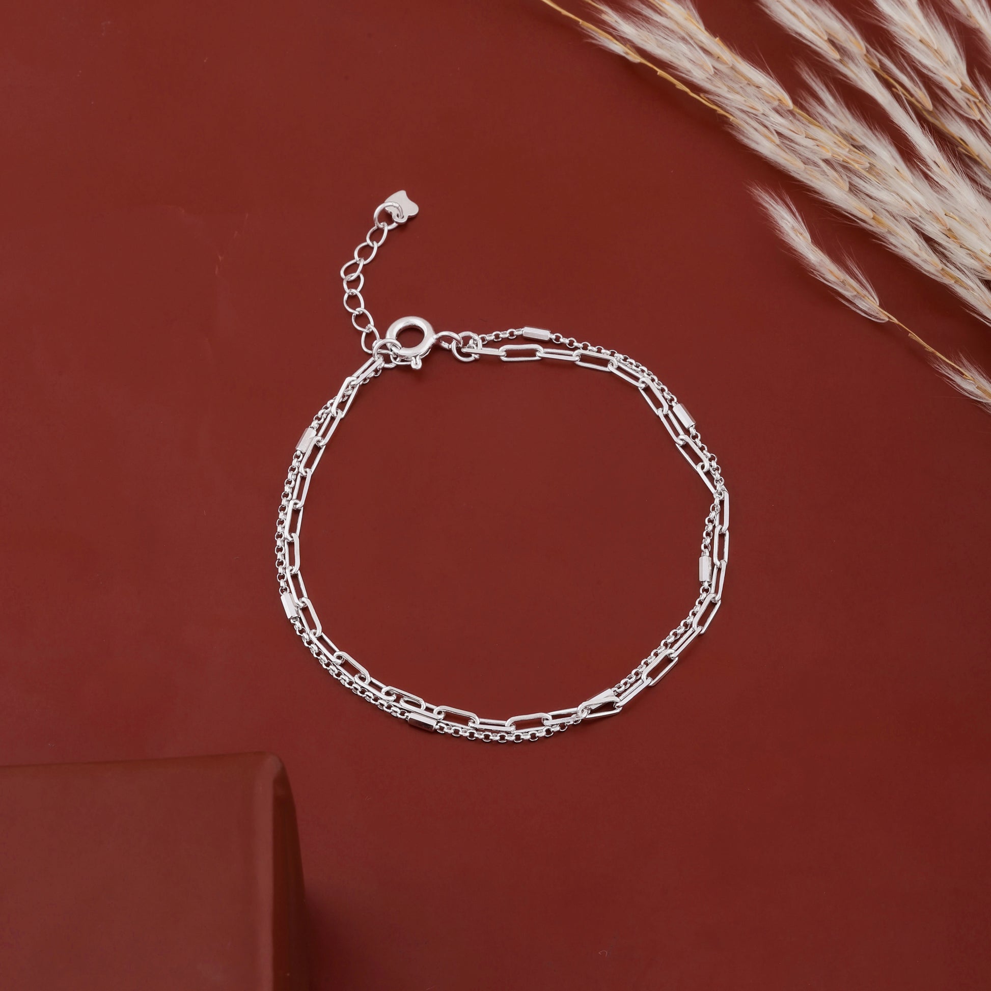 Sterling silver layered chain bracelet placed on black stone