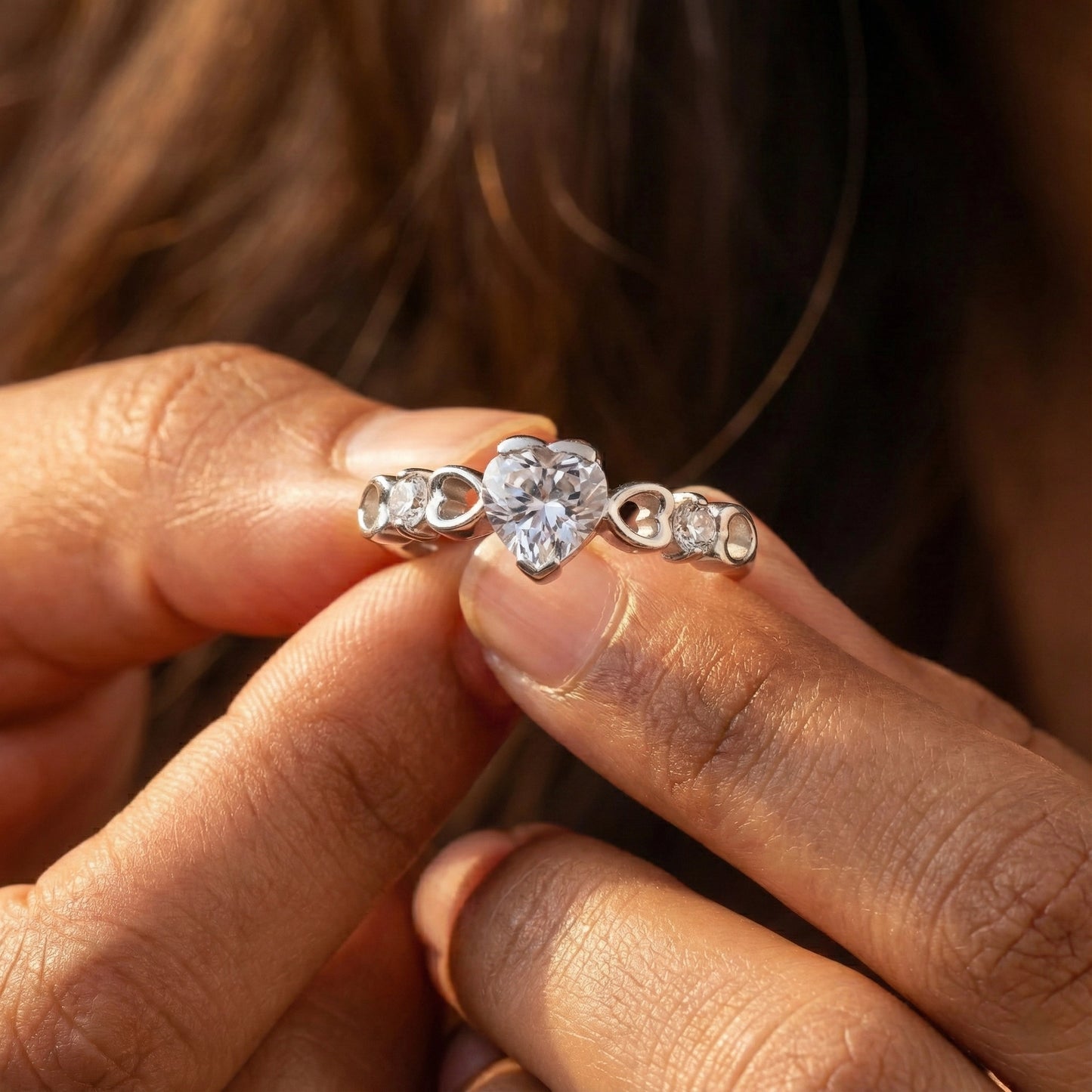 Close-up of hands holding two diamond rings.