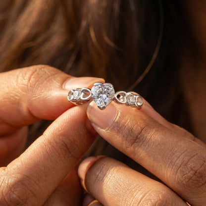 Close-up of hands holding two diamond rings.