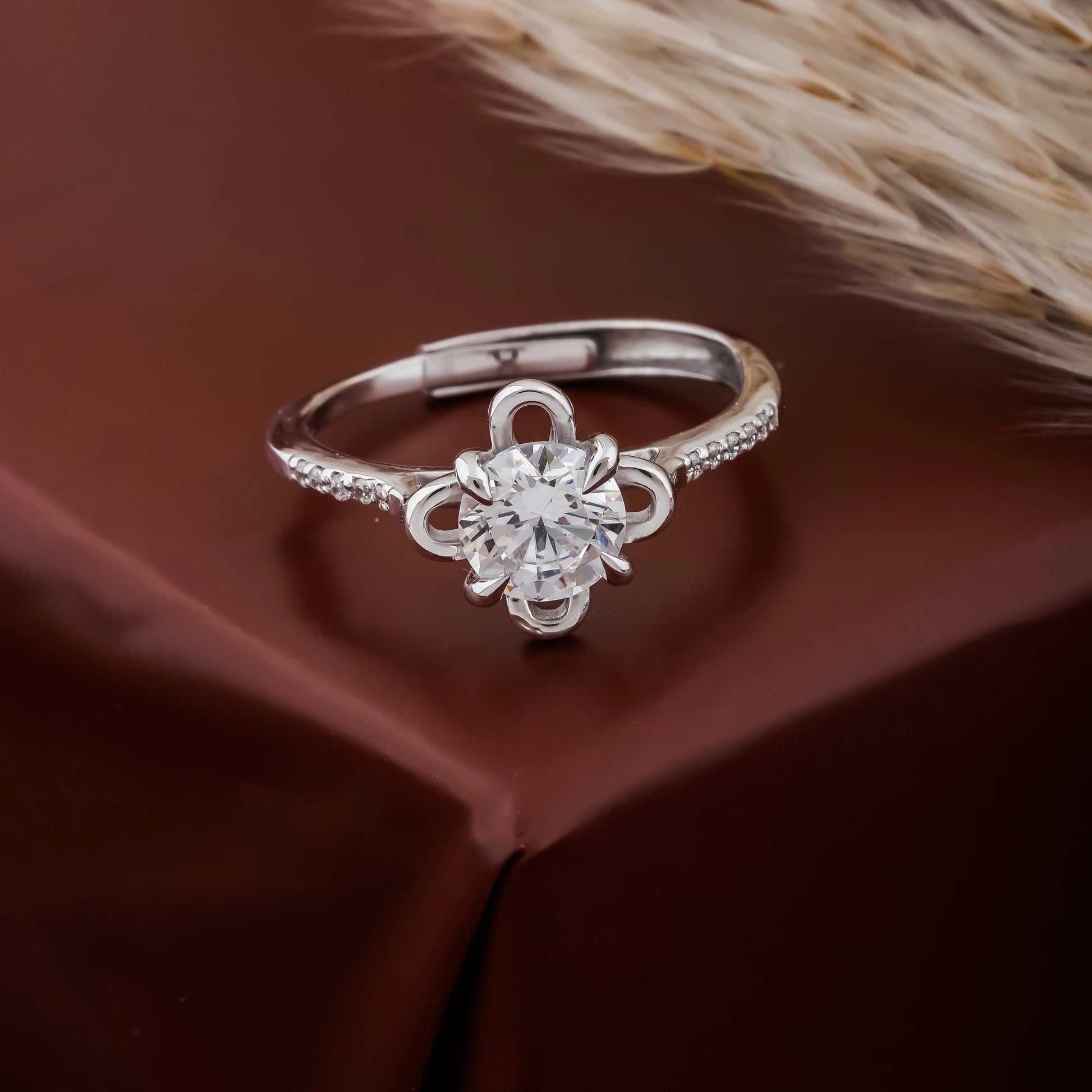 Silver ring with a diamond on a brown fabric background