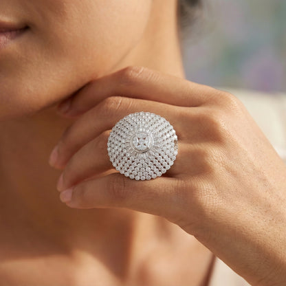 Close-up of a hand wearing a sparkling silver ring with a blurred background