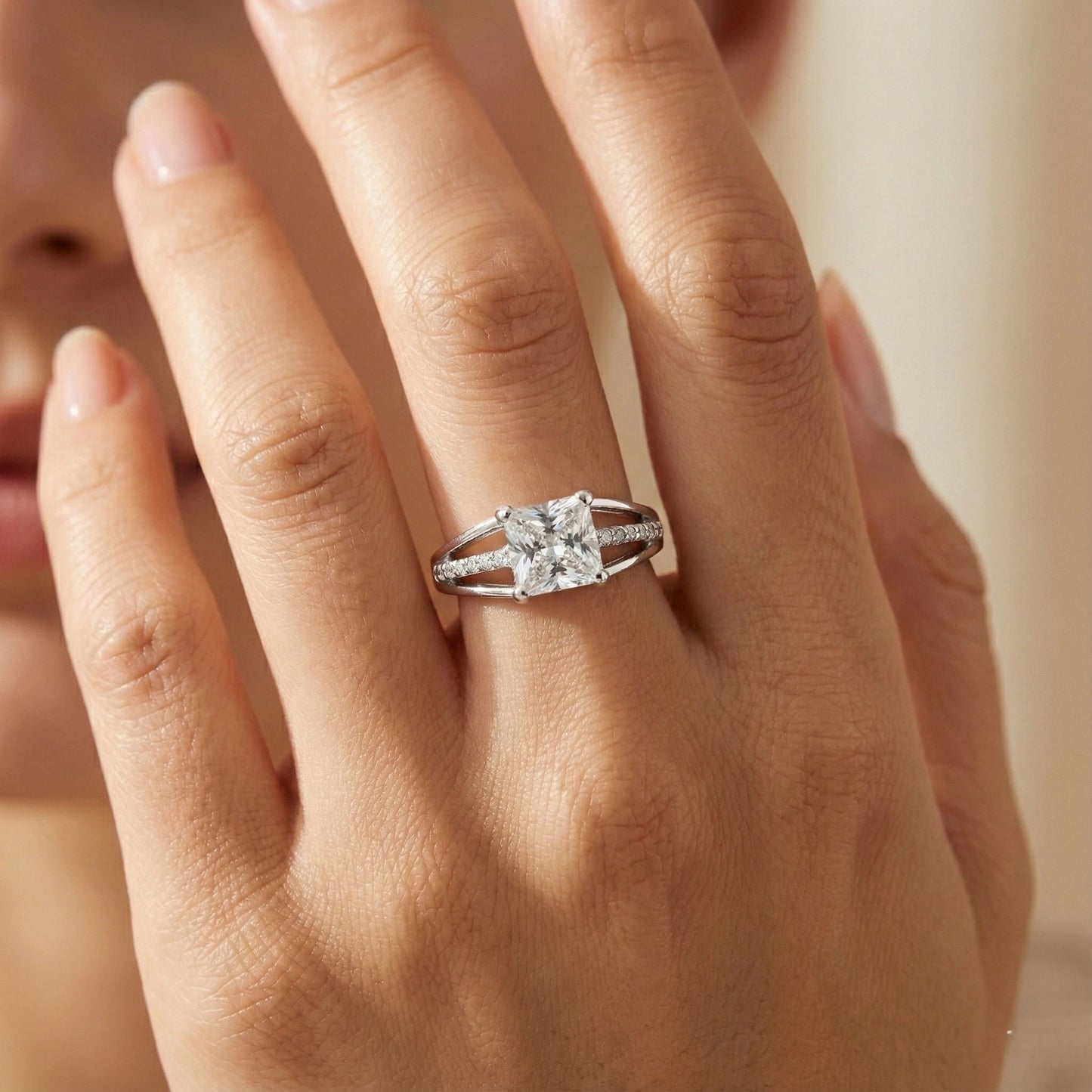 Close-up of a hand wearing a diamond ring with a blurred background