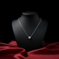 Silver necklace on a black mannequin bust with a red fabric background