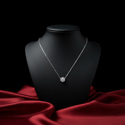 Silver necklace on a black mannequin bust with a red fabric background