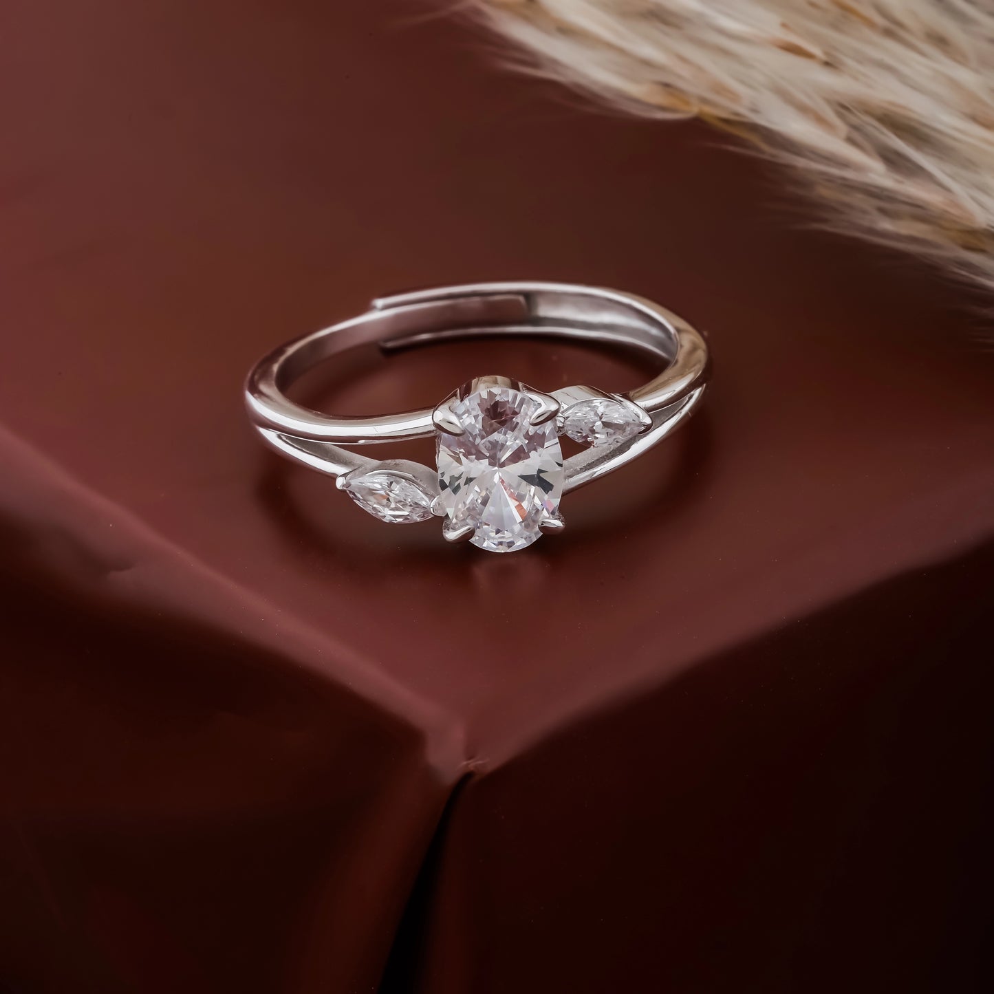 Silver ring with a diamond on a brown fabric background