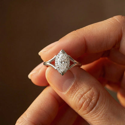 Diamond ring held between fingers against a blurred background