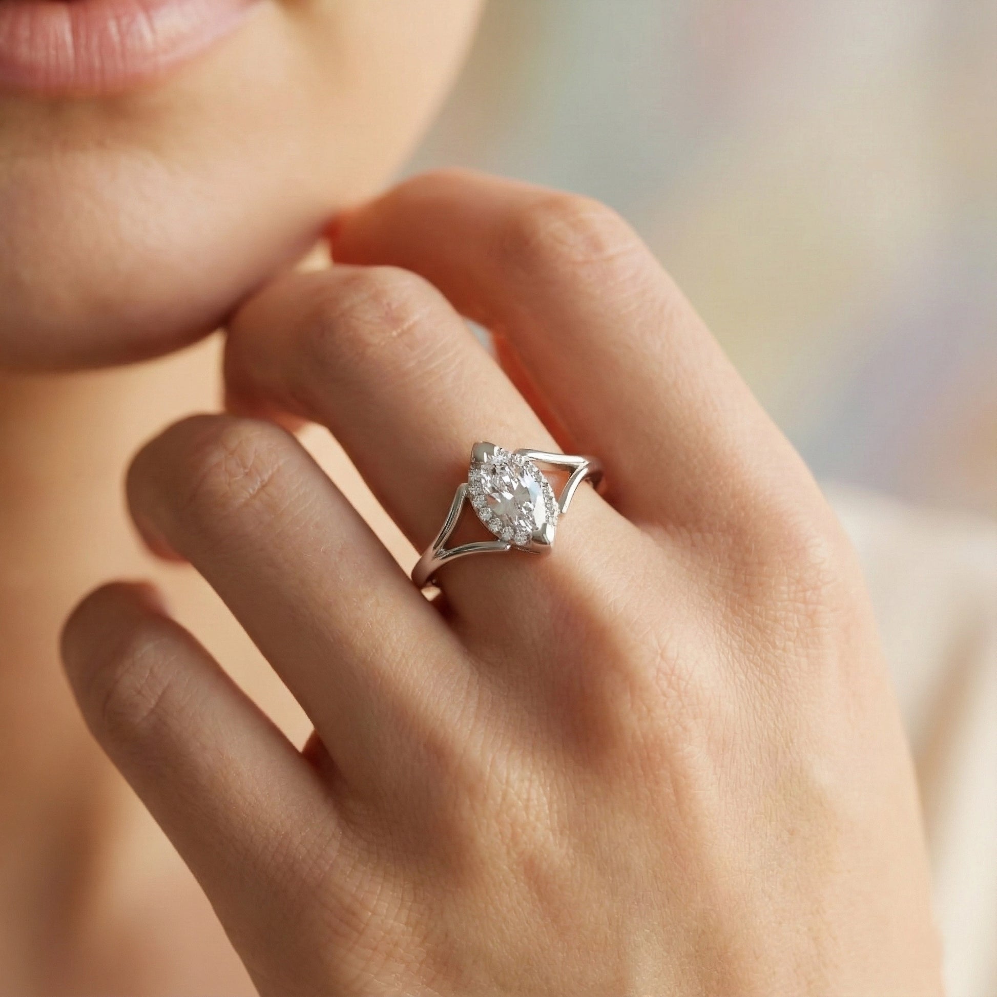 Close-up of a hand wearing a diamond ring with a blurred background