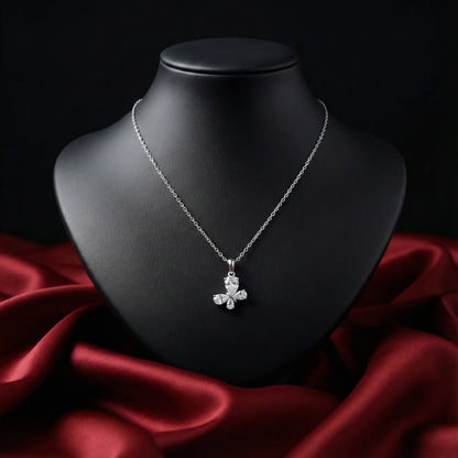 Silver necklace with a pendant on a black mannequin bust against a red fabric background