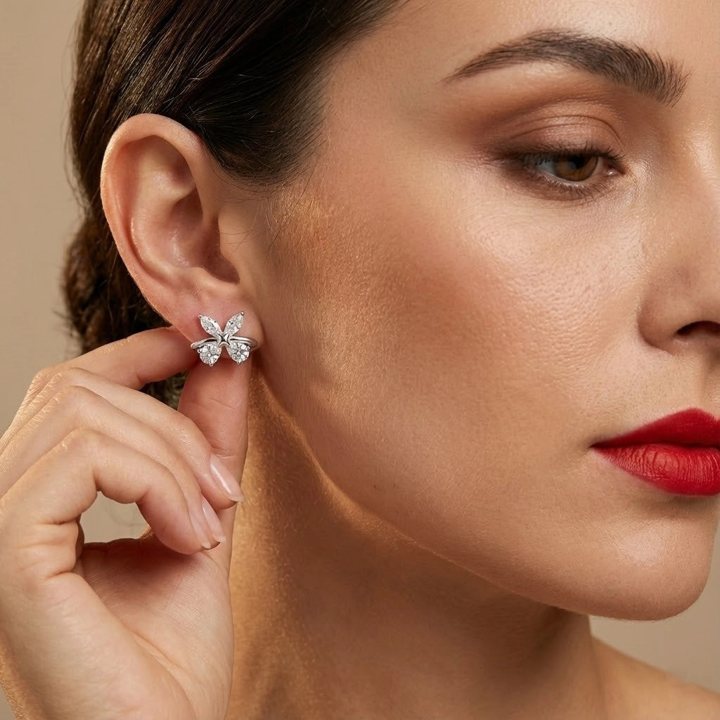 Close-up of a woman wearing a butterfly-shaped earring with a neutral background