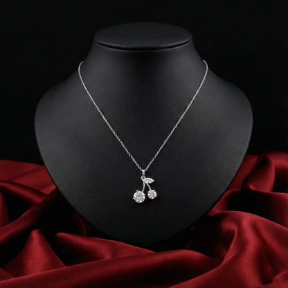 Silver necklace with a cherry pendant on a black mannequin bust against a red fabric background