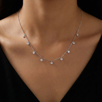 Silver necklace with small diamonds on a person wearing a black top