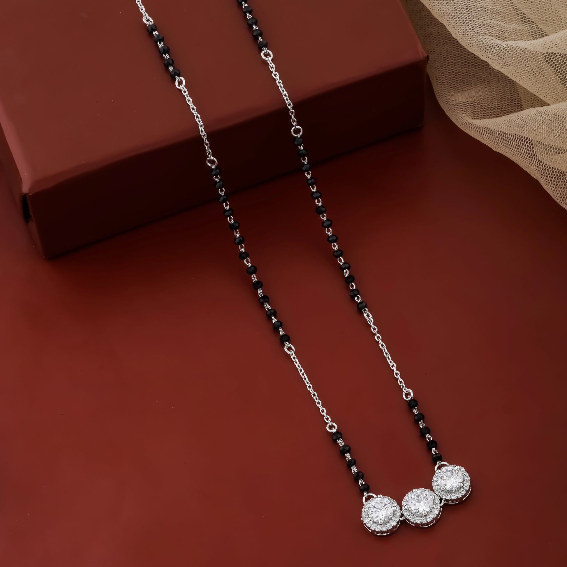 Necklace with black and silver beads on a brown surface