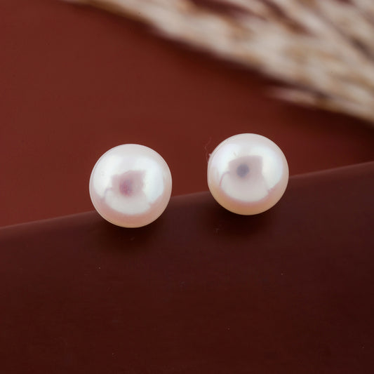 Pair of pearl earrings on a brown surface