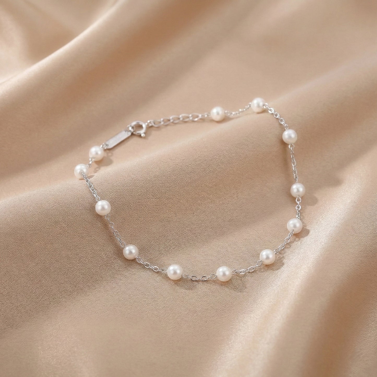 Sterling silver bracelet with white pearls placed on a black stone