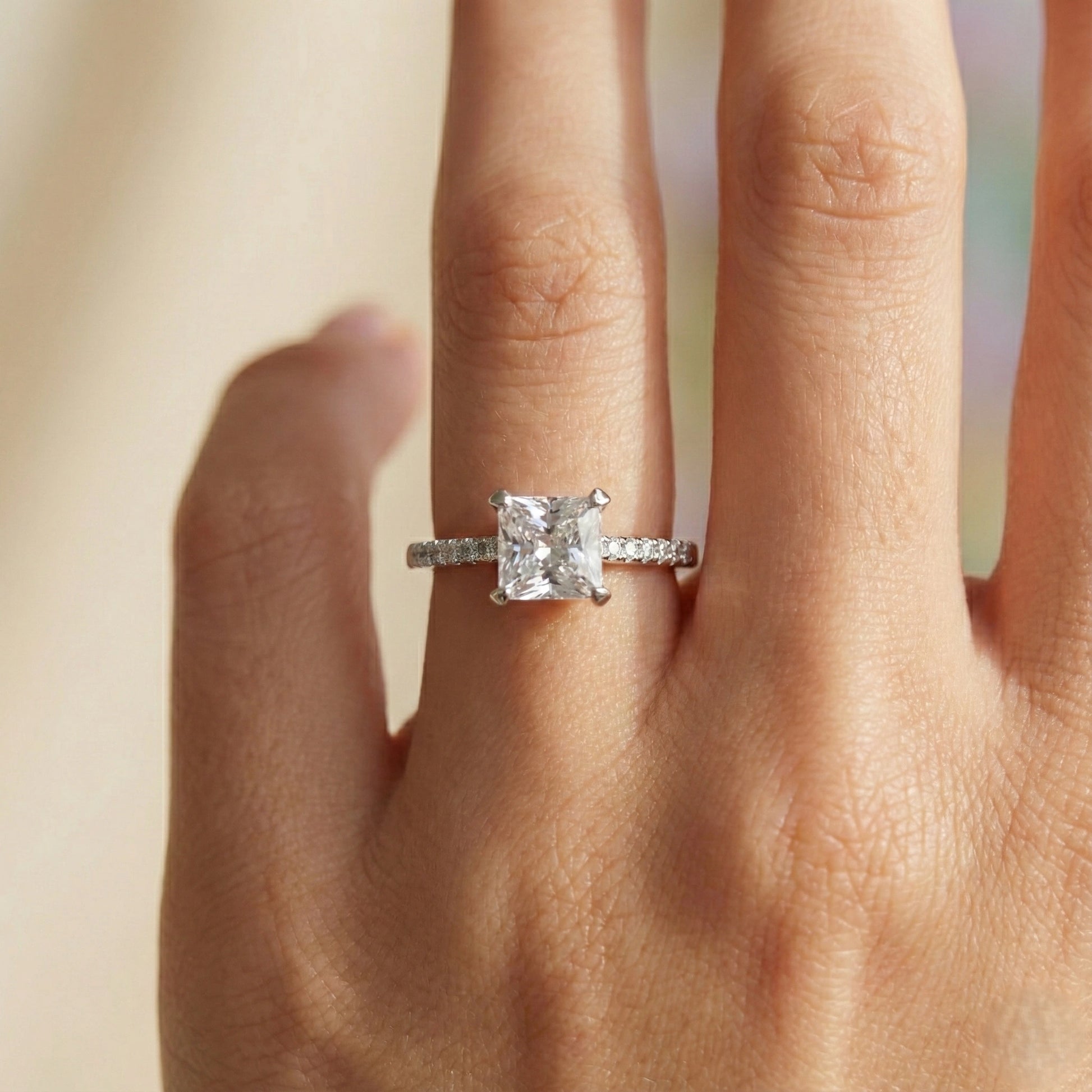 Diamond ring on a finger with a blurred background
