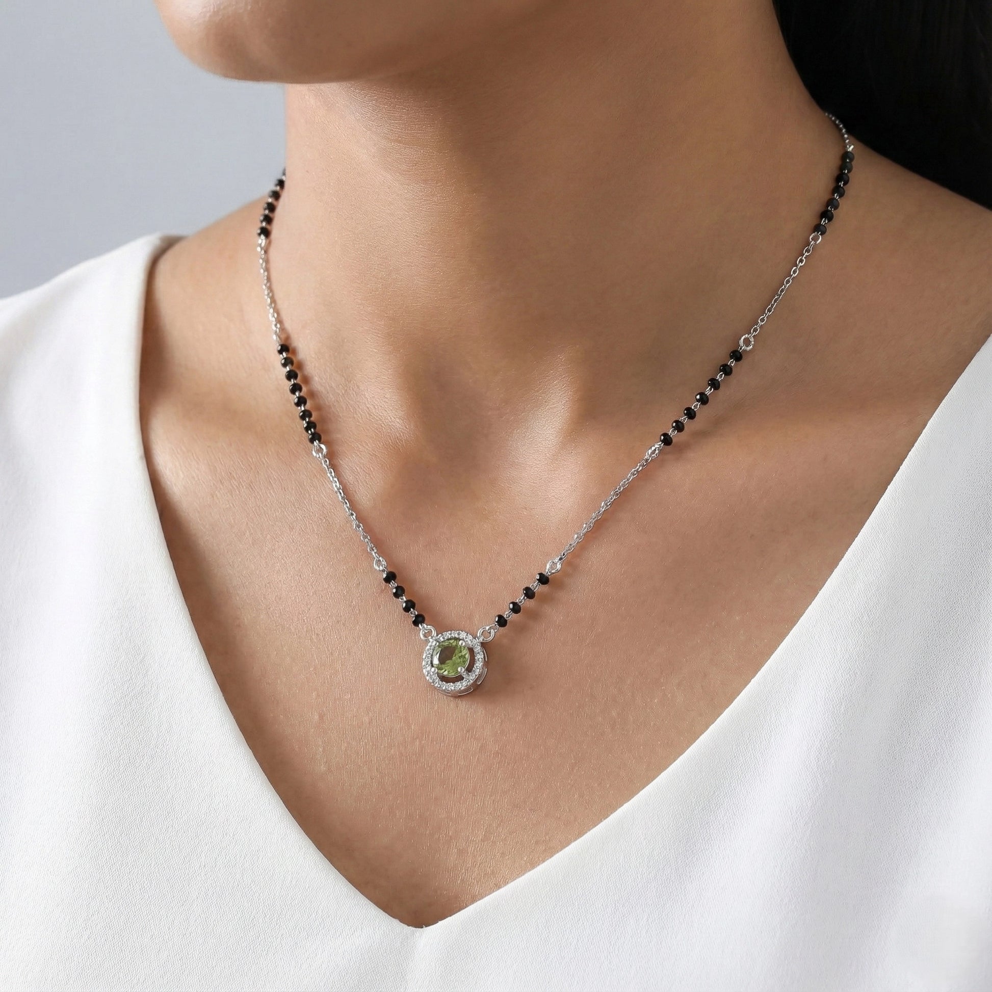 Minimal silver mangalsutra with traditional black beads and circular green stone pendant