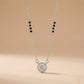 Necklace with a round pendant and black beads on a beige background