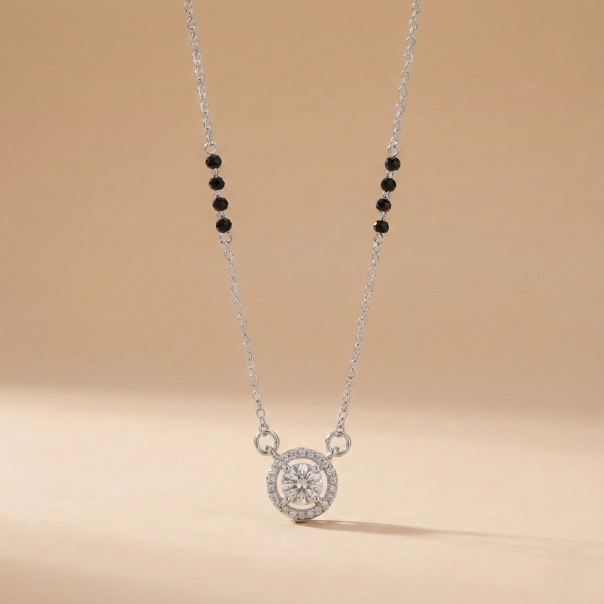 Necklace with a round pendant and black beads on a beige background