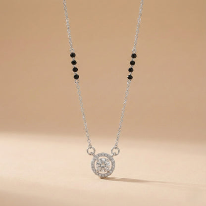 Necklace with a round pendant and black beads on a beige background